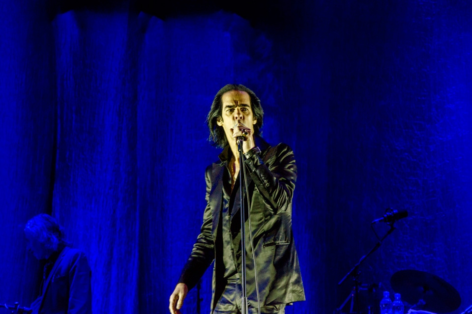 ...and under the cover of darkness, Nick Cave takes to the stage